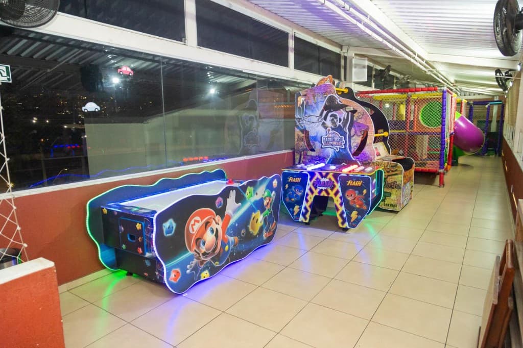Corredor do playground com arcades e brinquedão.